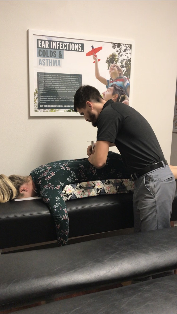 A Roots chiropractor gently adjusting a patient during a focused, hands-on session