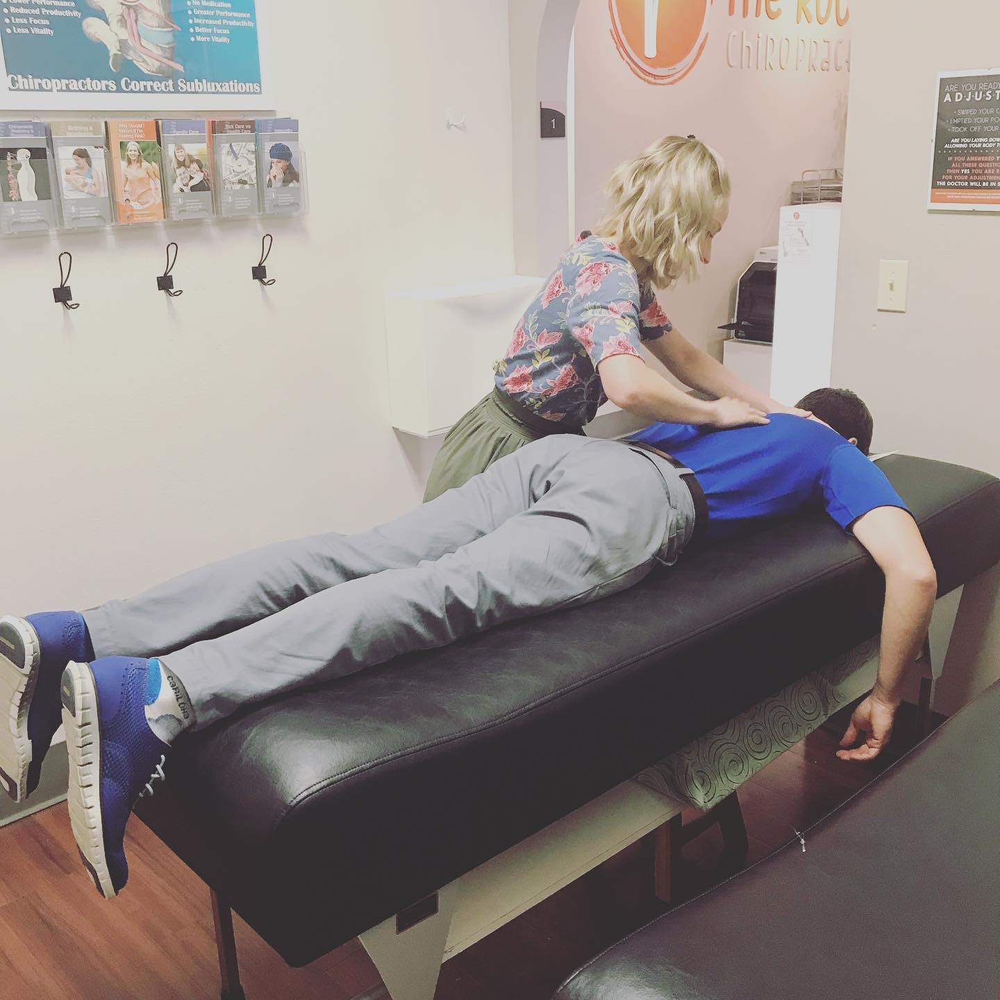 A chiropractor adjusting a teenage patient in the treatment room